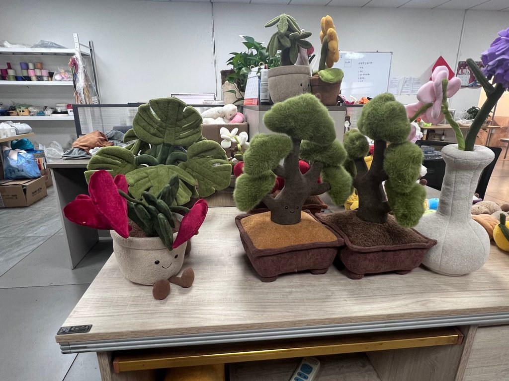 Custom plush plants and bonsai potted plush toys wholesale displayed on showroom table by Bolai Toys
